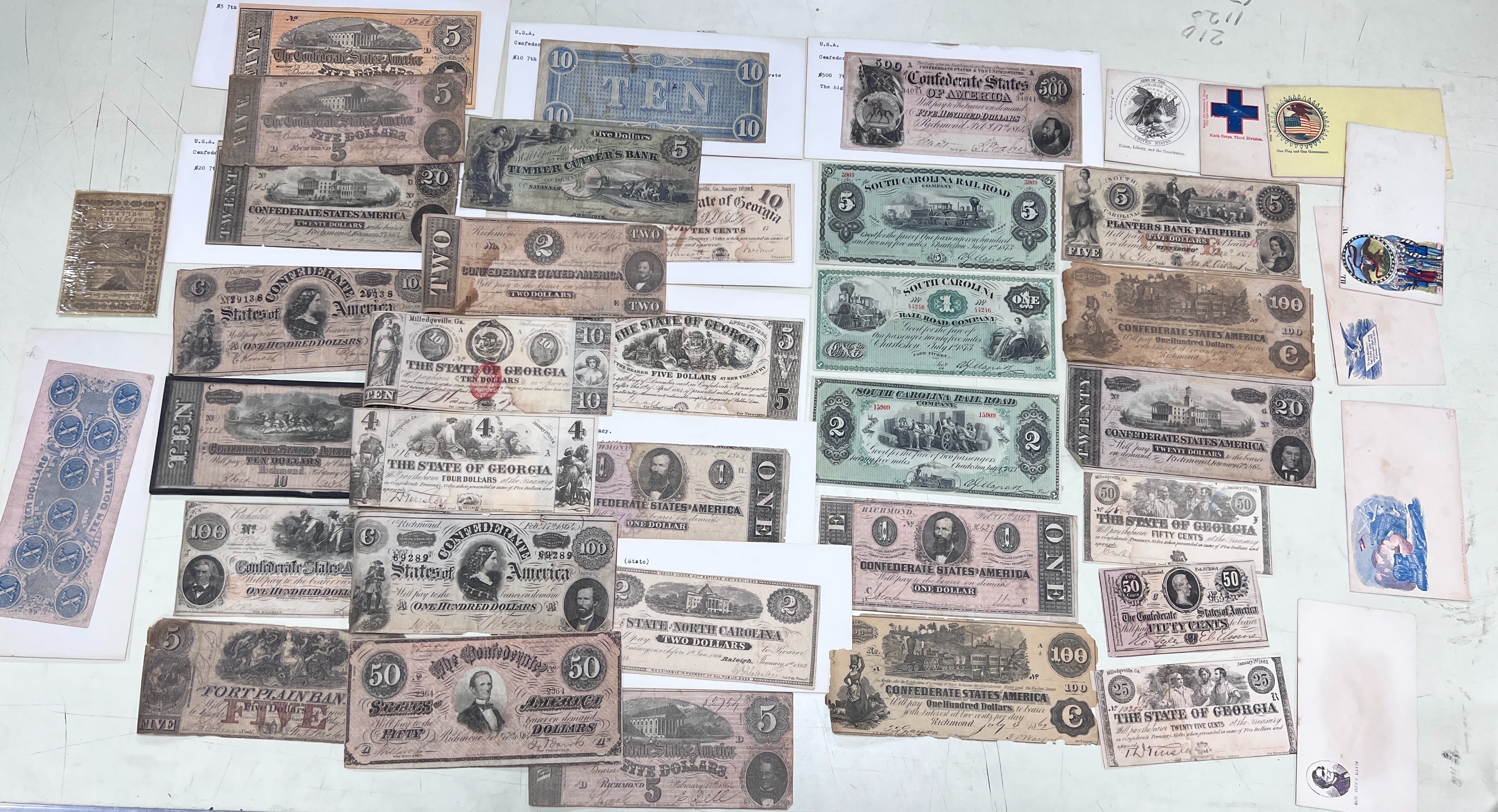 A collection of US Confederate States banknotes, including a confederate states of America $500 seventh issue 17 February 1864, $100 Richmond July 4 1862 x 2 and another 1864, and many others